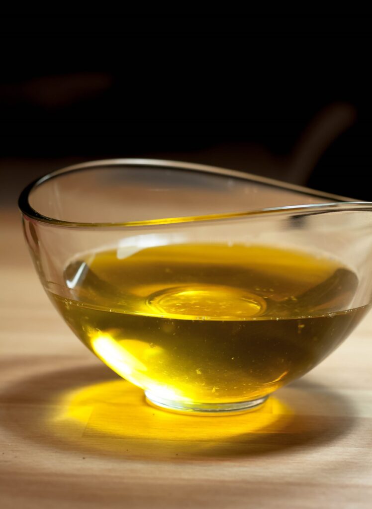 fluessige-geklaerte-butter-rim-Glas-auf-tisch-mit-dunkem-hintergrung