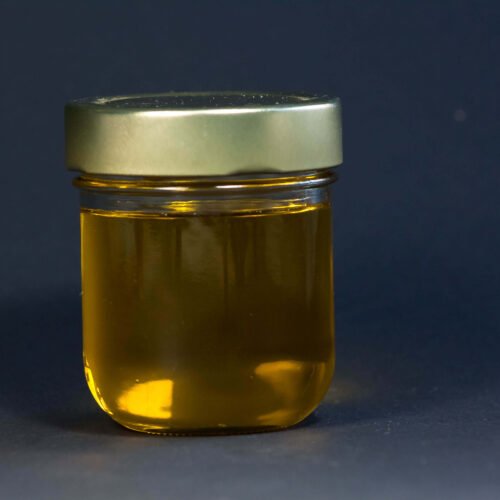 geklaerte-butter-erkaltet-in- einem Glas vor-dunklem-hintergund