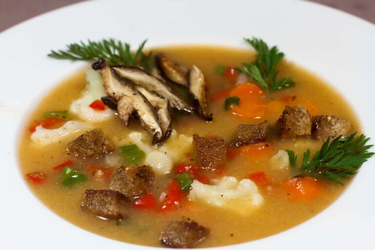 Gemuesesuppe-mit-verschiedenen-Gemuesesorten-und-Croutons-m-Teller-als-Nahaufnahme