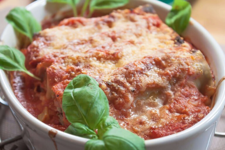 Canneloni-mit-Tomatensauce-in-Schuessel-mit-Basilikum-und-Parmensan