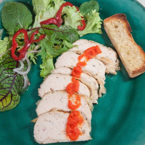 Haehnchen-Pate-in-scheiben-gechnitten-mit-kleinem-Salat-auf-gruenen-Teller