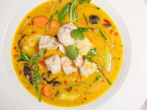 curry-fischsuppe-mit-kokosmilchpack-choi-und-shiitakepilzen-in-weissem-Teller