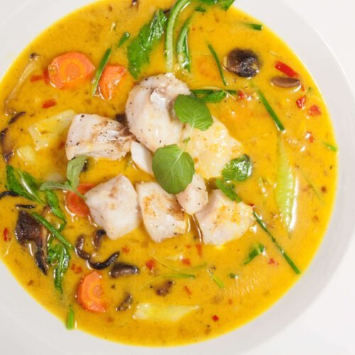 curry-fischsuppe-mit-kokosmilchpack-choi-und-shiitakepilzen-in-weissem-Teller