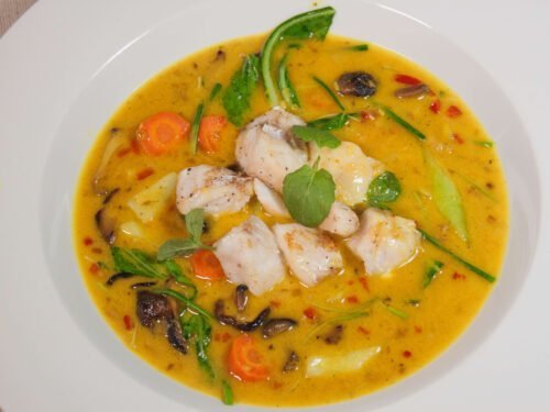curry-fischsuppe-mit-kokosmilchpack-choi-und-shiitakepilzen-in-weissem-Teller