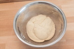 Hefeteig-fuer-Spanische-Pizza-in-Metallschuessel-Arbeitsflaeche