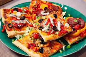 Pizzateig 4 https://oxbe.de/wp-content/uploads/2023/01/download.png Spanische-Pizza-mit-GEmuese-und-Salami-belegt-auf-gruenem-Teller