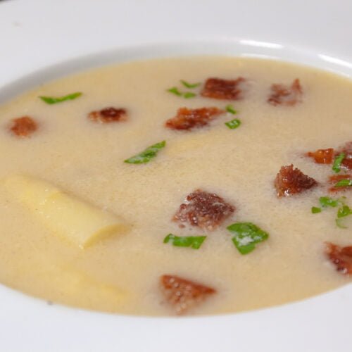 Spargelcremesuppe-in-weissem-Teller-mit-croutons-und-kreutern