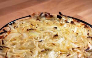 Fugazzeta 7 https://oxbe.de/wp-content/uploads/2023/01/download.png Fertig-gebackene-Fugazzeta-im-BAckblech-auf-Arbeitsflaeche