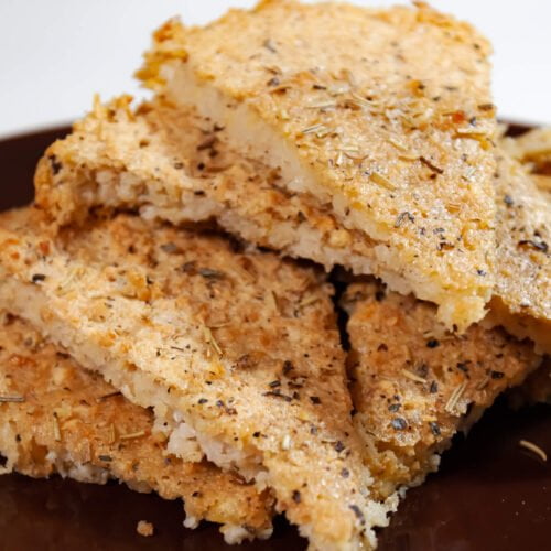 Fertiger-Fainá-Kuchen-in-Backform-auf-Fertieg-Kuchenstuecke-auf-braunem-Teller