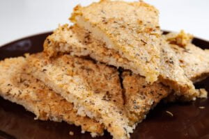 Fainá 12 https://oxbe.de/wp-content/uploads/2023/01/download.png Fertiger Fainá Kuchen in Backform auf Fertieg Kuchenstücke auf braunem Teller