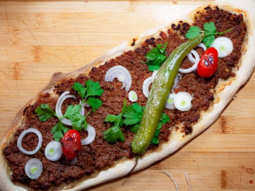 Lahmacun 15 https://oxbe.de/wp-content/uploads/2023/01/download.png Lahmacun-frisch-aus-dem-Ofen-belegt-mit-gergrillten-tomaten-petersielie-und-paprika-auf-Abritsbrett