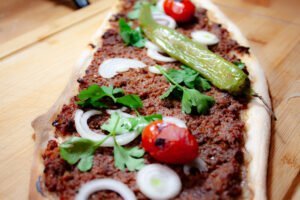 Pizzateig 18 https://oxbe.de/wp-content/uploads/2023/01/download.png Lahmacun-mit-geroesteten-Tomaten-Petersielie-und-Zwiebeln-in-Nahaufnahme-auf-Holzbrett