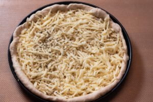 Fugazzeta 5 https://oxbe.de/wp-content/uploads/2023/01/download.png Mozzarella-auf-Hefeteig-in-Pizzaform-ausgelegt-auf-Arbeitsflaeche-