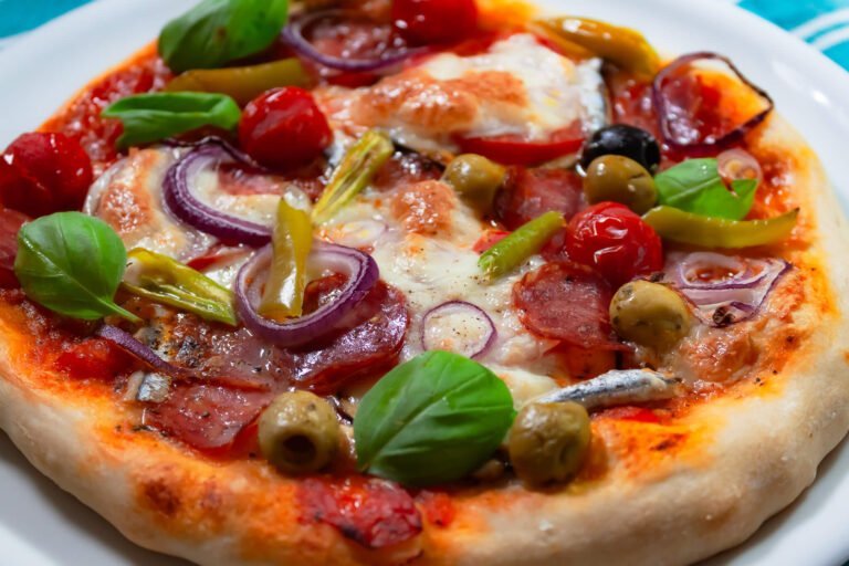 Salami Pizza 2 https://oxbe.de/wp-content/uploads/2023/01/download.png Fertige-Salamipizza-mit-Zwiebeln-Mozerella-Paeperoni-und-Cherrytomaten-auf-weissem-Teller-