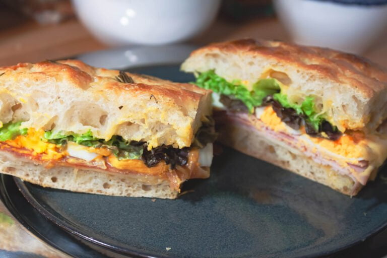 Focaccia 5 https://oxbe.de/wp-content/uploads/2023/01/download.png Focaccia-Sadwich-mit-Schninken-Ei-und-Salat-auf-schwarzem-Teller-
