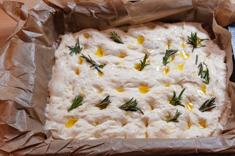 Focaccia 10 https://oxbe.de/wp-content/uploads/2023/01/download.png Focaccia-Teig-im-BAckpapier-mit-Rosmarien-fertig-zum-backen