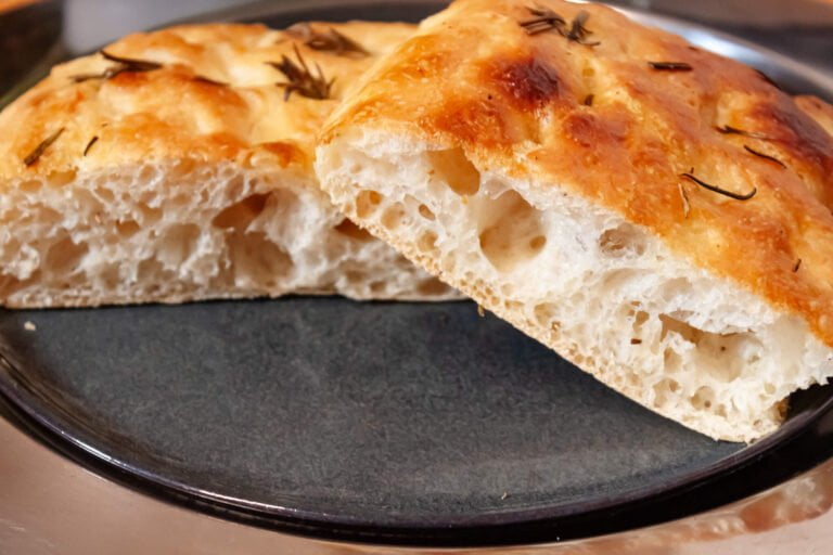 Focaccia 11 https://oxbe.de/wp-content/uploads/2023/01/download.png Focaccia-fertig-gebacken-und-geschnitten-auf-schwarzem-Teller.