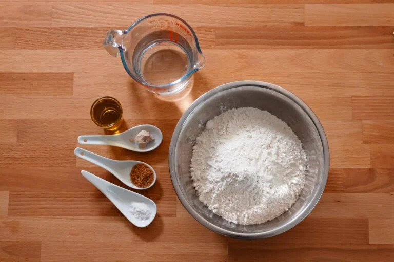 Pizzateig 8 https://oxbe.de/wp-content/uploads/2023/01/download.png Grundzutaten-fuer-Pizza, Mehl-wasser-olivenoel-salz-zucker-hefe-auf-Bambusarbeitsflaeche