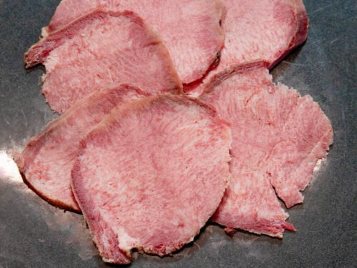 Rinderzunge aufgeschnitten auf schwarzen Teller