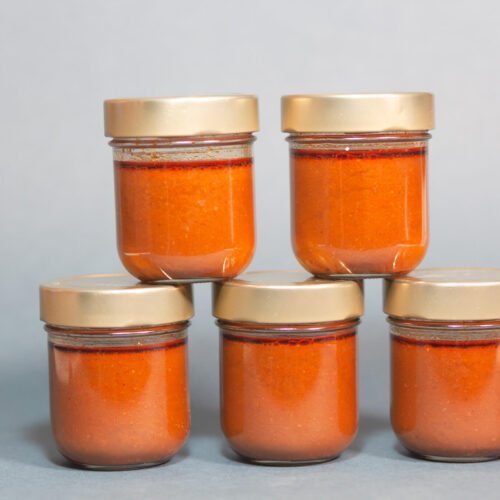 Tomatensauce in Gläser abgefüllt auf blauem Hintergrund