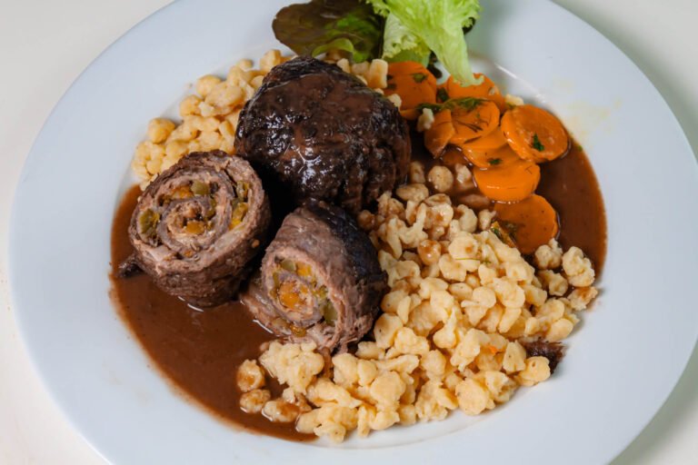 Geschmorte Rimderroulade mit shenespaezle,butterkarotten und dunkler sacue auf weissem teller-6